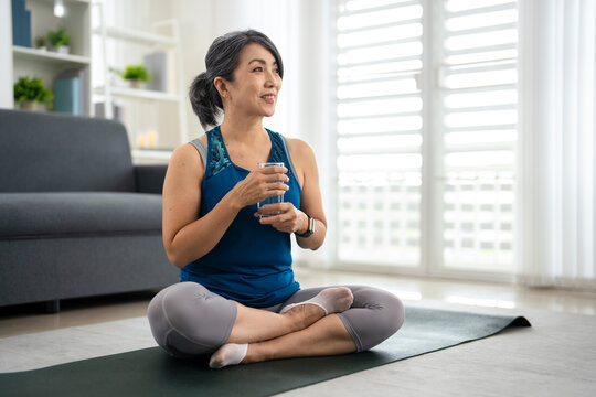 Drinking water. Woman resting after exercise and workout at home.