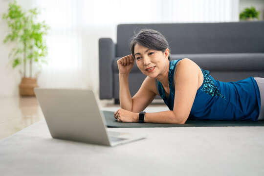 Fitness workout at home. woman watching and following excercise tutoria online on laptop computer.