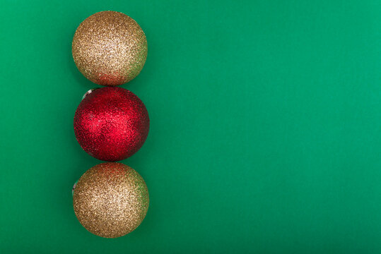 Red and Gold Christmas Ornaments on Green Background