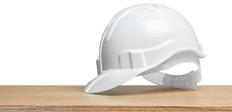 White hard hat on wooden table with plain background in workplace setting