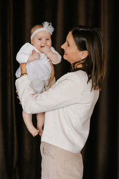 Mother Holding Little Baby and looking Profile