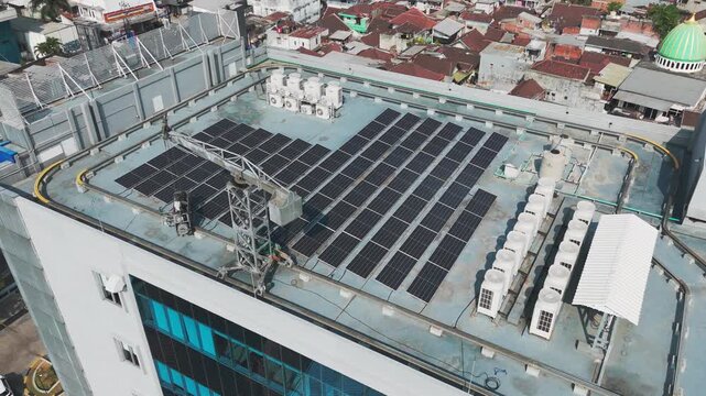 Aerial view of solar panels and HVAC units on a building rooftop in Malang, East Java, Indonesia.