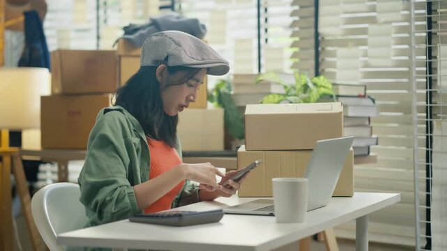Asian woman merchant checking inventory stock with AI agent on laptop,smartphone platform.women use AI agent for e-commerce entrepreneur online seller managing business delivery and service at home
