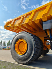 Smalyavichy, Belarus - June 14, 2025: Belaz huge dump truck with large tire and yellow cargo bed © Slepitssskaya
