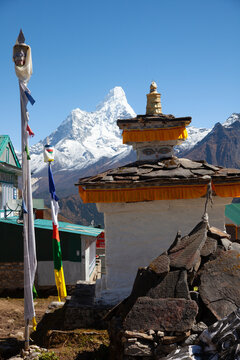 Mountain view with stupa and prayer flags near a village in Nepal during the day