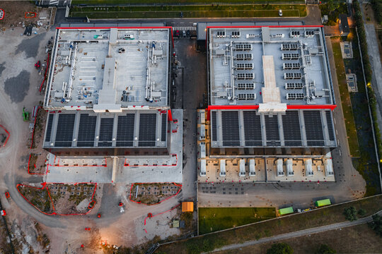 Aerial view of the Aruba Hyper Cloud Datacenter IT4 facility featuring modern industrial buildings with solar panels on rooftops, cooling systems, and surrounding infrastructure in Roma, Lazio, Italy.