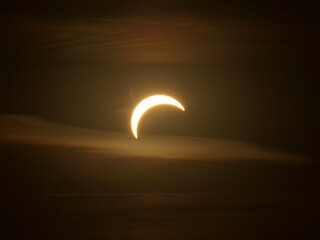 Advanced partial solar eclipse on August 12, 2026 north of Dornheim in Thuringia, Germany. The partially obscured Sun appears as a narrow luminous crescent between dark layers of clouds in the sky. © Frank