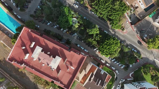 Top down flight over villas with pools and winding streets in Malaga, Spain.