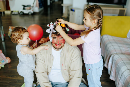 Pretend play beauty salon model father posing for daughters. Creative role play game at home