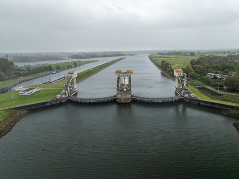 Aerial view of Sluis- en stuwcomplex Hagestein, a large lock and weir complex on the Lek River, surrounded by green banks and agricultural fields in Hagestein, Utrecht, Netherlands.