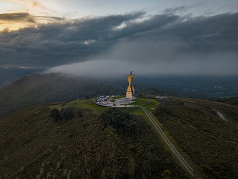 Monte Naranco Sacred Heart of Jesus monument aerial photo in misty cloudscape above Oviedo, Asturias, Spain.