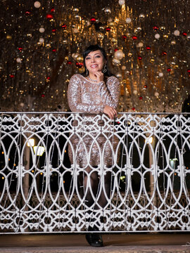 Woman in Elegant Dress Posing at a Festive Christmas Gazebo at Night