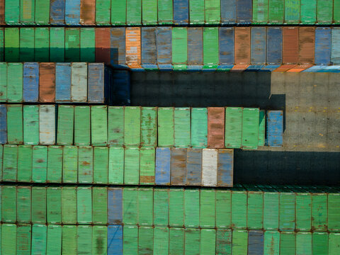 Aerial view of numerous colorful shipping containers neatly stacked in a large industrial storage yard in Boyolali, Central Java, Indonesia.