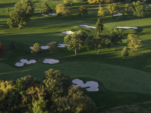 Aerial view of a golf course in autumn with vibrant fall foliage, sand bunkers, and manicured green fairways in Glenview, Illinois, United States.