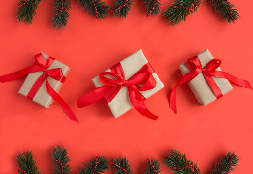 Christmas gifts with tiew red bow on a red background. Top view.