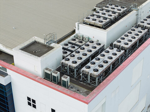 Aerial view of a data center rooftop featuring rows of industrial HVAC cooling units and ventilation systems in the United Kingdom.
