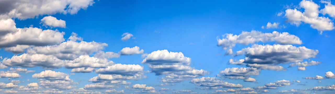 Rows soft steam stretch forming a striking natural pattern. Cloud layers moving dynamically right to left. Cumulus clouds clusters warm summer day vast blue sky. Large copy space above for writing.