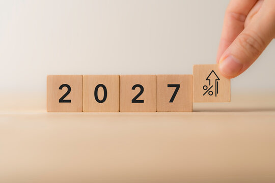 2027 Financial Growth. Rising Interest Rates, Economic Outlook. Placing a wooden block with an upward percentage with 2027. Rising interest rates, financial growth, economic trends, future forecasts.