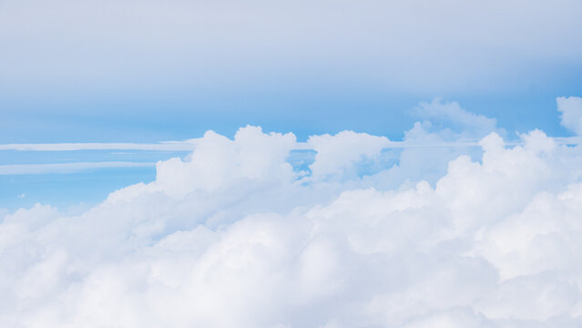 Aerial view of fluffy white clouds drifting across a bright blue sky in Choco, Colombia.