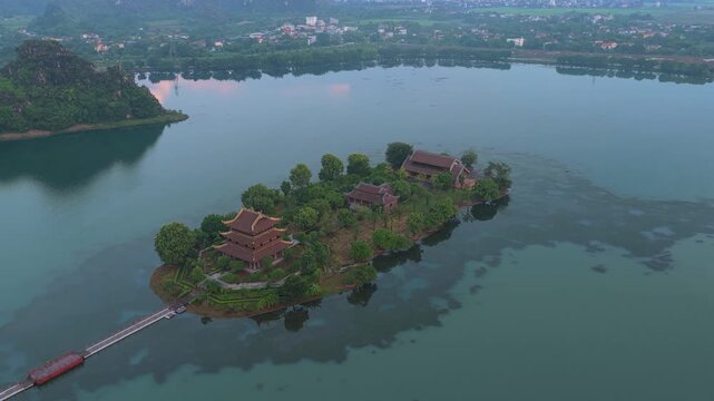 Golden pagoda on an island in hoa lu vietnam at sunrise