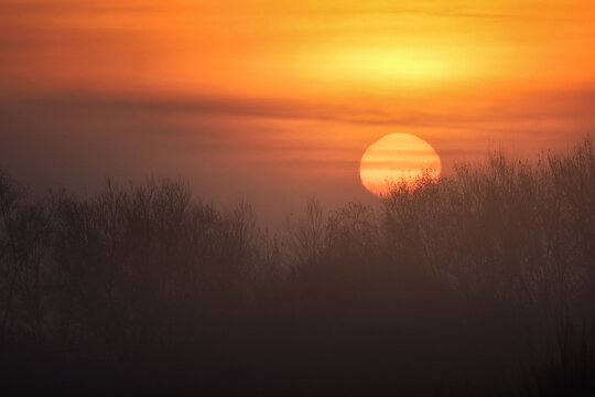 sun rising from behind the clouds in autumn