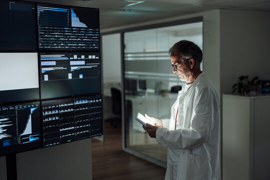 Doctor examining data on tablet in high tech hospital room