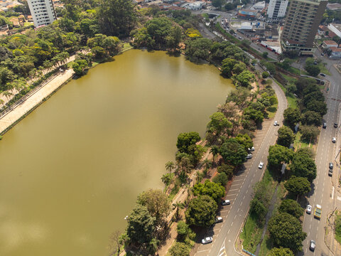 Aerial view of Parque Municipal Fabio da Silva Prado - Lago Municipal with its large lake, surrounding trees, walking paths, and adjacent urban roads in Araras, Sao Paulo, Brazil.