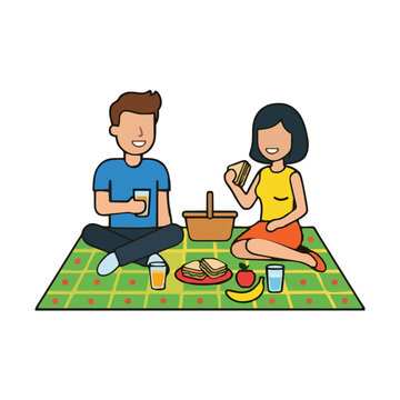 Happy young couple eating sandwiches on a picnic blanket, enjoying a romantic summer outdoor lunch date