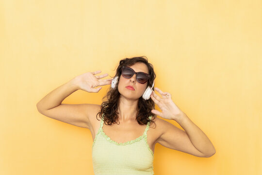 Woman listening music wearing sunglasses and headphones