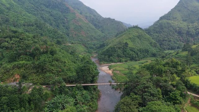 Lush green mountain valley with river and bridge in ha giang, vietnam