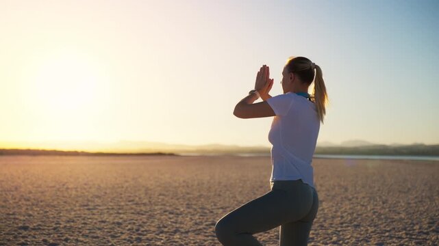 Woman practicing yoga on vast desert landscape, focusing on balance, stability and body awareness. Outdoor yoga scene illustrating physical wellness, flexibility, concentration, healthy lifestyle