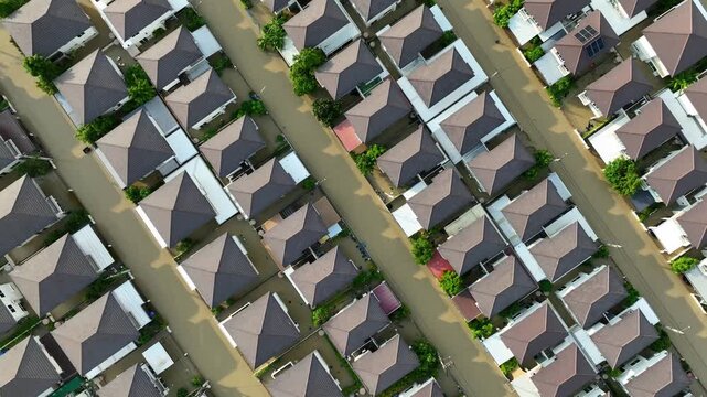 Rows of suburban homes stand amid widespread floodwater after heavy rain, illustrating the effects of urban flooding on residential areas, transportation access, and community safety. 4k.
