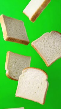 Multiple slices of freshly baked white bread falling slowly in midair against a solid chroma key green background with no clipping at the edges