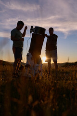 Amateur astronomers preparing telescope during sunset for night observations of stars, Milky Way, Moon and Planets. © astrosystem