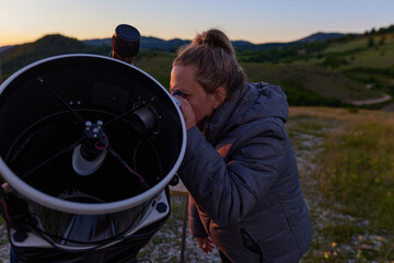 Amateur astronomer observing stars, planets, Moon and other celestial objects with a telescope in nature. © astrosystem