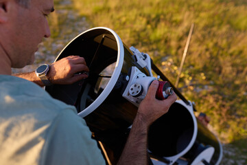 Amateur astronomer preparing and collimating telescope during sunset for night observations of stars, Milky Way, Moon and Planets. © astrosystem