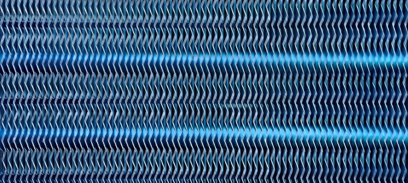 A close-up of metallic fins arranged in a corrugated zigzag pattern, typical of heat exchangers or radiator systems. 