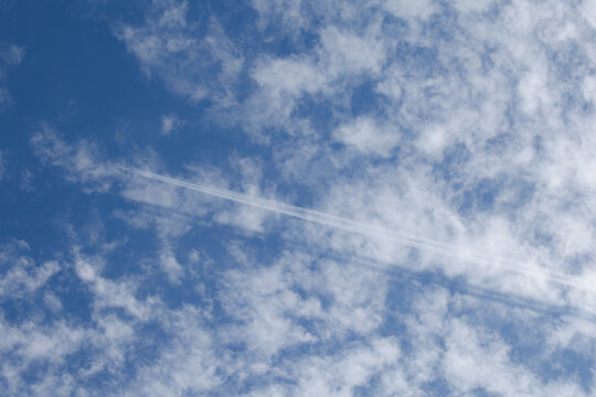 うろこ雲に飛行機雲の影が落ちている様子