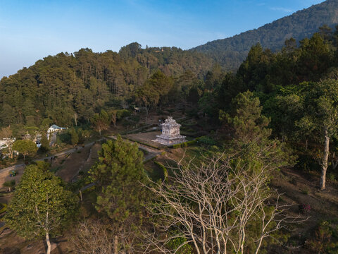 Aerial view of Gedong Songo Temple nestled on the slopes of Mount Ungaran, surrounded by lush pine forests and rolling hills in Bandungan, Jawa Tengah, Indonesia.