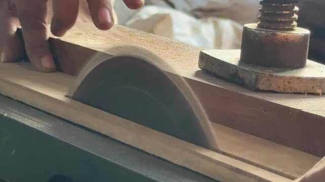 Vertical close up of circular saw cutting wood on table saw in workshop