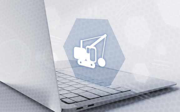 Una aplicaci&oacute;n inform&aacute;tica especializada muestra un icono de construcci&oacute;n digital sobre una laptop moderna, simbolizando la gesti&oacute;n tecnol&oacute;gica industrial y la automatizaci&oacute;n digital.