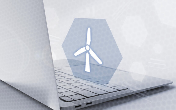 Una computadora port&aacute;til con una interfaz digital y un icono de turbina e&oacute;lica en pantalla, representando energ&iacute;a renovable, tecnolog&iacute;a ecol&oacute;gica y sostenibilidad.