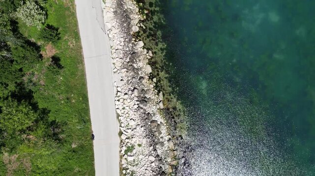 Aerial Top Down View of Rocky Coastline Turquoise Sea Water and Road