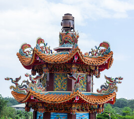 Hualien Gangtian Temple in Taiwan featuring colorful dragon roof decorations and traditional Taiwanese architectural ornaments against blue sky. © Eugene Ga