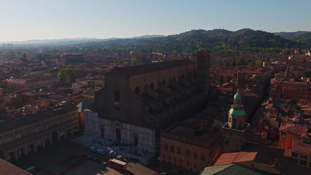 Aerial drone view of Basilica di San Petronio in Bologna, Italy, showcasing its monumental fa&ccedil;ade, historic architecture, Piazza Maggiore, and surrounding old town cityscape.