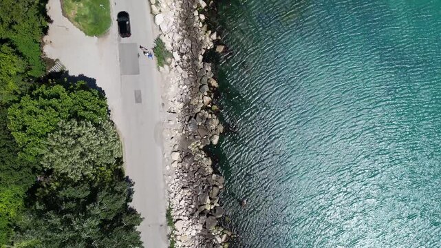 Aerial Top Down View of Rocky Coastline Turquoise Sea Water and Road
