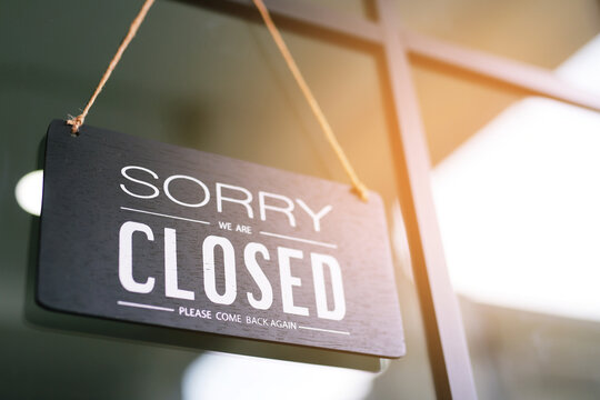 The sign is holding up the shop closing sign. closed sign on shop door. Text on cafe front or restaurant hang on door at entrance. vintage tone style. banner.