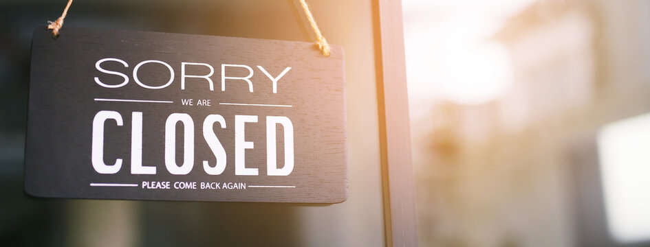 The sign is holding up the shop closing sign. closed sign on shop door. Text on cafe front or restaurant hang on door at entrance. vintage tone style. banner.