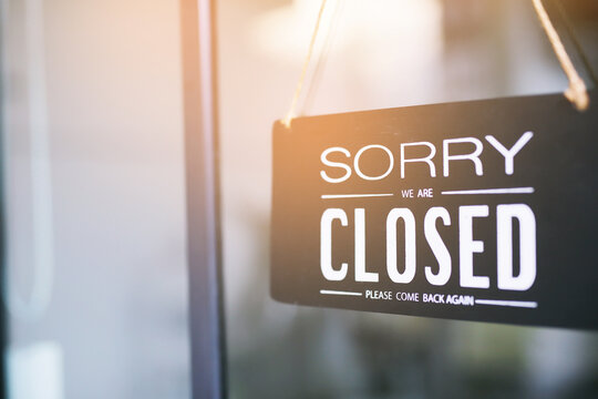 The sign is holding up the shop closing sign. closed sign on shop door. Text on cafe front or restaurant hang on door at entrance. vintage tone style. banner.