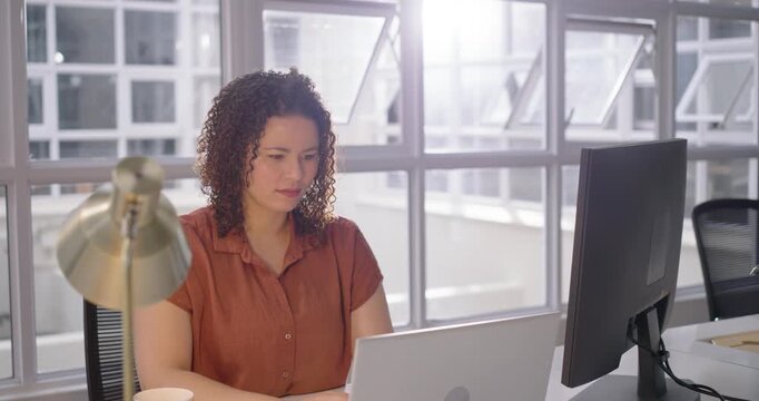 African American woman typing on laptop in office seeing glare reaching monitor checking smiling